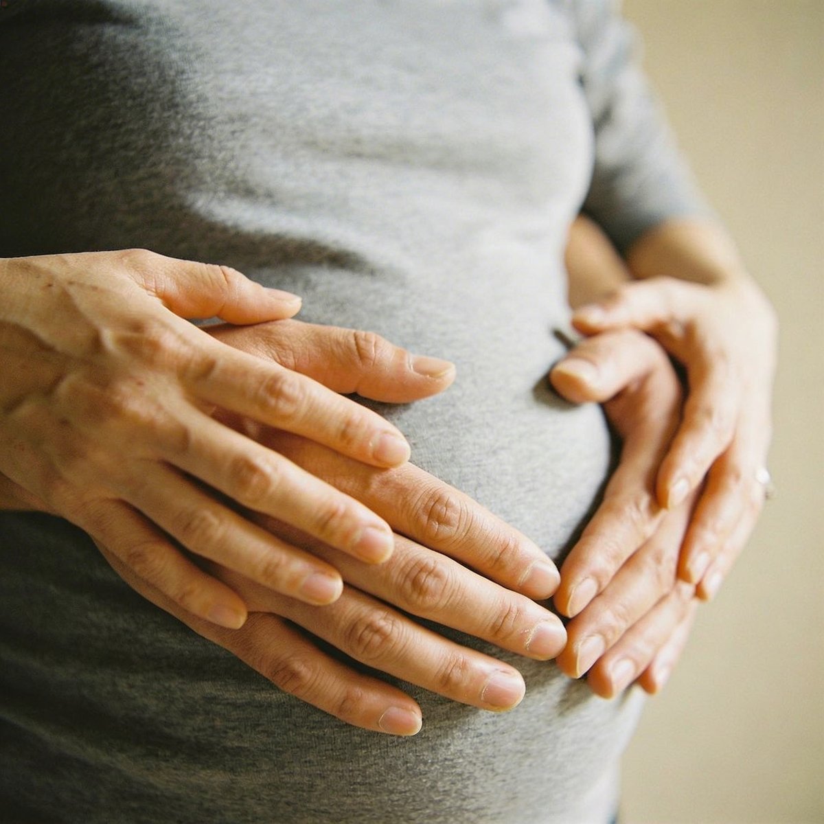 Mani sul pancione durante il servizio fotografico maternità